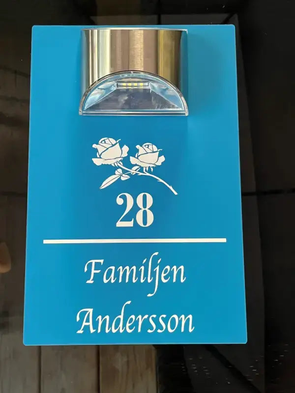 Hus nummerskylt med namn och belysning