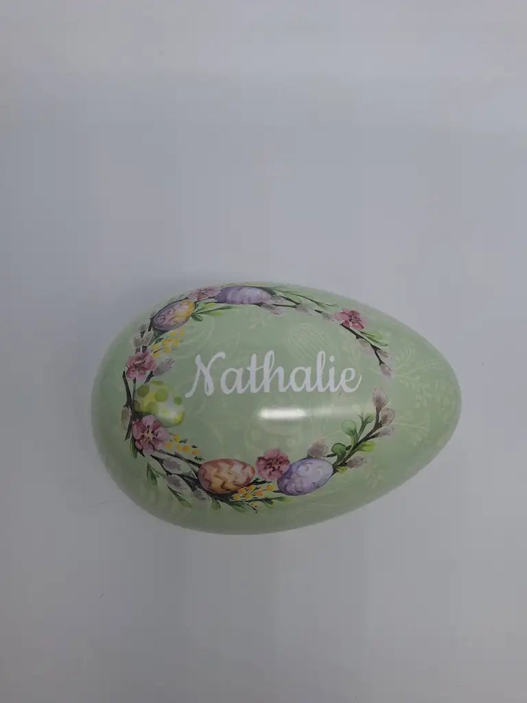 Påskägget från Expresspresenter.se är ett 15 cm stort ljusgrönt ägg dekorerat med blommor och äggmönster, med namnet Nathalie i vit skrift i mitten på en vit bakgrund.