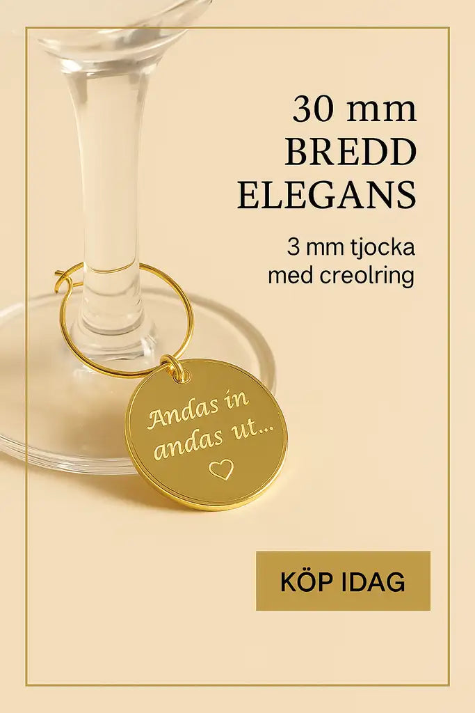 Dekoration till glas från Expresspresenter.se: En elegant, spegelliknande guld 30 mm akryletikett med texten "Andas in andas ut..." och ett hjärta, hänger i en 3 mm creolring på vinglasets fot. Köp idag!.