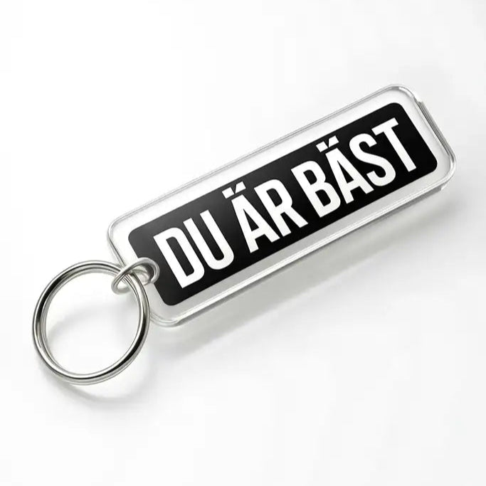 Nyckelringen Du är bäst by Express-presenter är en silverfärgad nyckelring med en rektangulär svartvit tagg med budskapet "Du är bäst" på en vit yta.