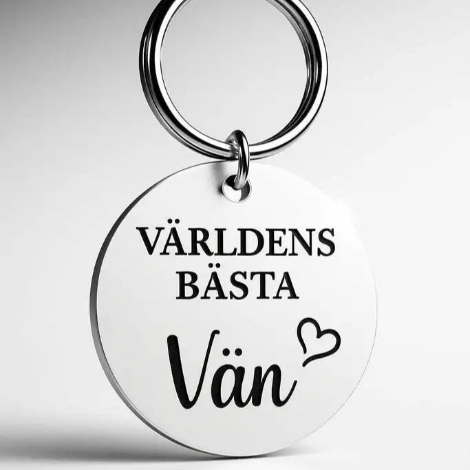 Nyckelring | Världens bästa vän (vit) från Express-presenter - en rund graverad nyckelring med texten "Världens bästa vän" och ett hjärta, perfekt som personlig present till din bästa vän.
