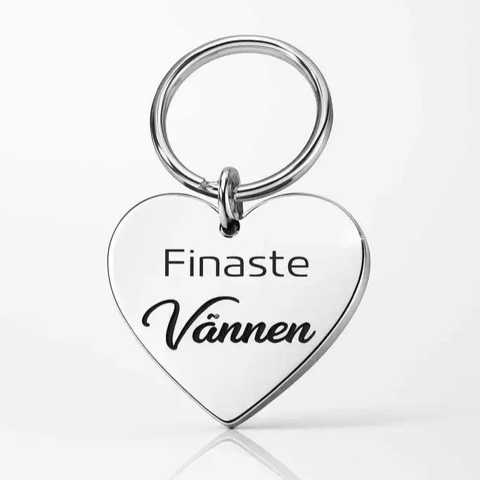 Express-presenter Nyckelring | Finaste vännen (Vit) - en hjärtformad vit nyckelring med "Finaste Vännen" graverat, vilket betyder Finest Friend, visas mot vit bakgrund.