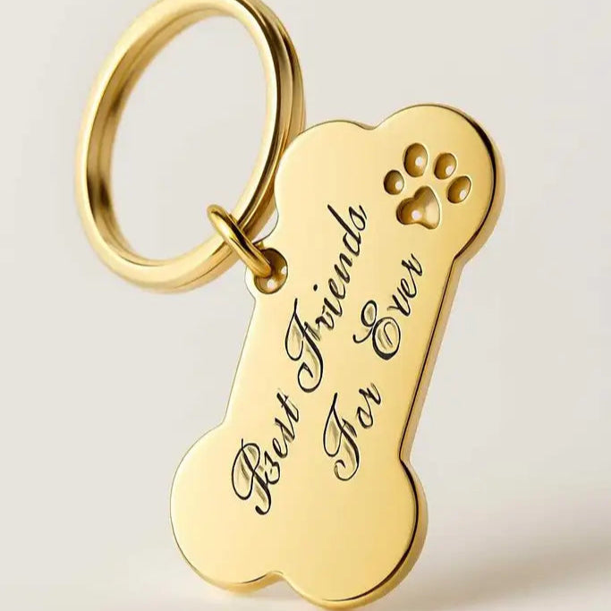 Nyckelring | Hundben Best friends for ever från Express-presenter i guld med lasergravyrtexten "Best Friends For Ever" och ett litet tassavtryck utskuret i övre högra hörnet, mot en enkel bakgrund.