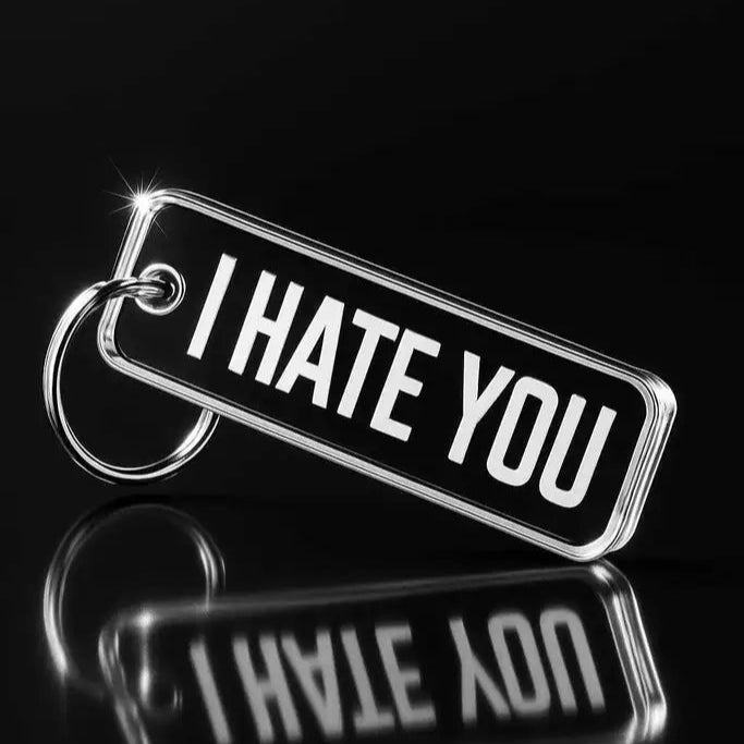 Nyckelringen | I hate you by Express-presenter är en nyckelring i metall med en svart tagg med texten "I HATE YOU" i feta vita bokstäver mot en mörk bakgrund med en spegelbild under.