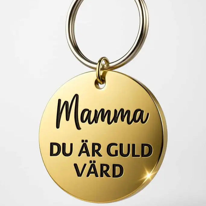 Nyckelring | Mamma du är guld värd från Express-presenter: guldfärgad plast, svart graverad text "Mamma, du är guld värd" på 40mm mot ljus bakgrund.