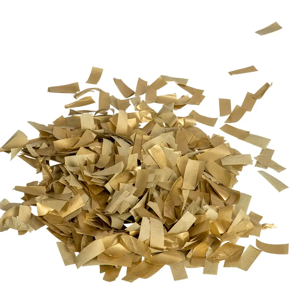 Konfetti i metalliskt guld från Express-presenter Konfettikanon GULD 60 cm sprids på en vit bakgrund, med några kraftpappersbitar bland huvudhögen.