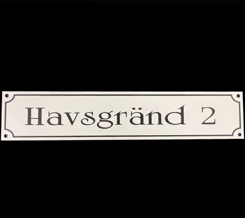 Adresskylt-Gatuvägskylt by Express-presenter är en vit rektangulär skylt (300×100 mm) tillverkad av slitstark akrylmaterial med "Havsgränd 2" i svart text på svart botten, dekorativa hörn och två små monteringshål.