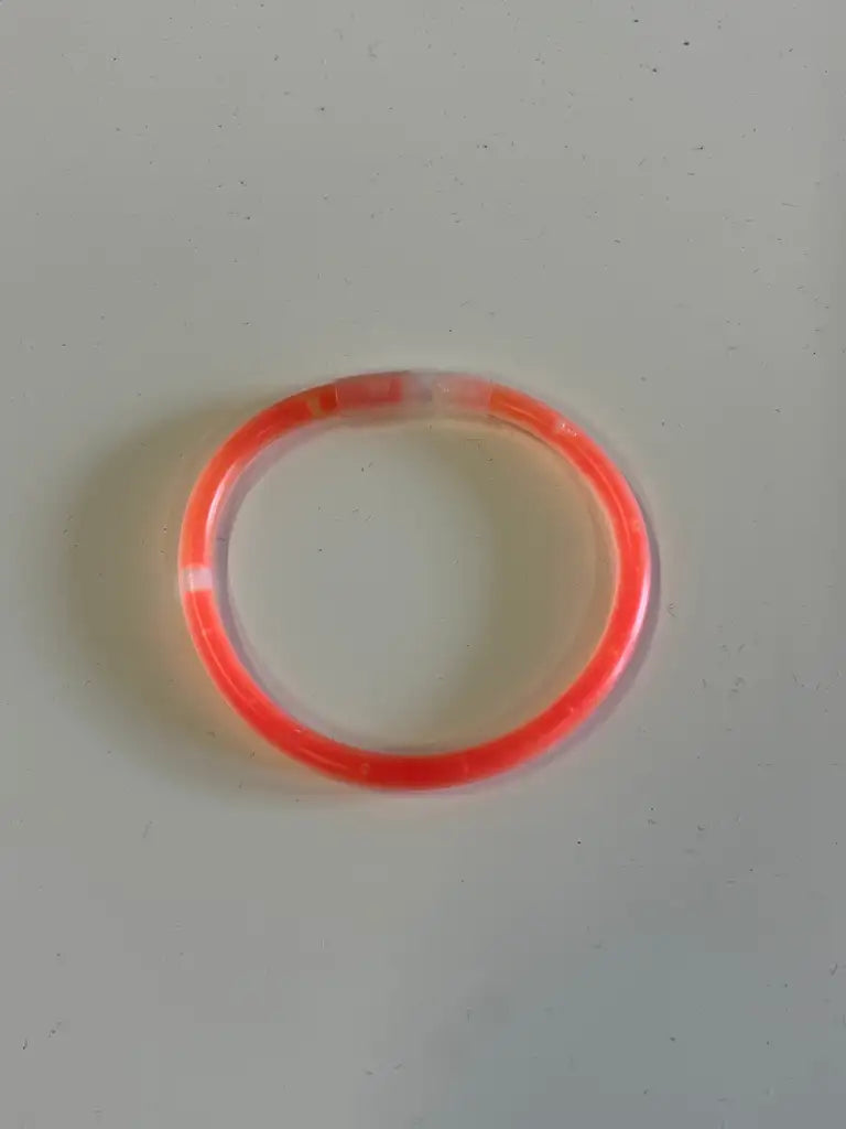 Express-presenter GLOW STICKS-armbandet, 20 cm långt, bildar en glödande sluten slinga på en ljusgrå yta - en iögonfallande accessoar för alla fester.