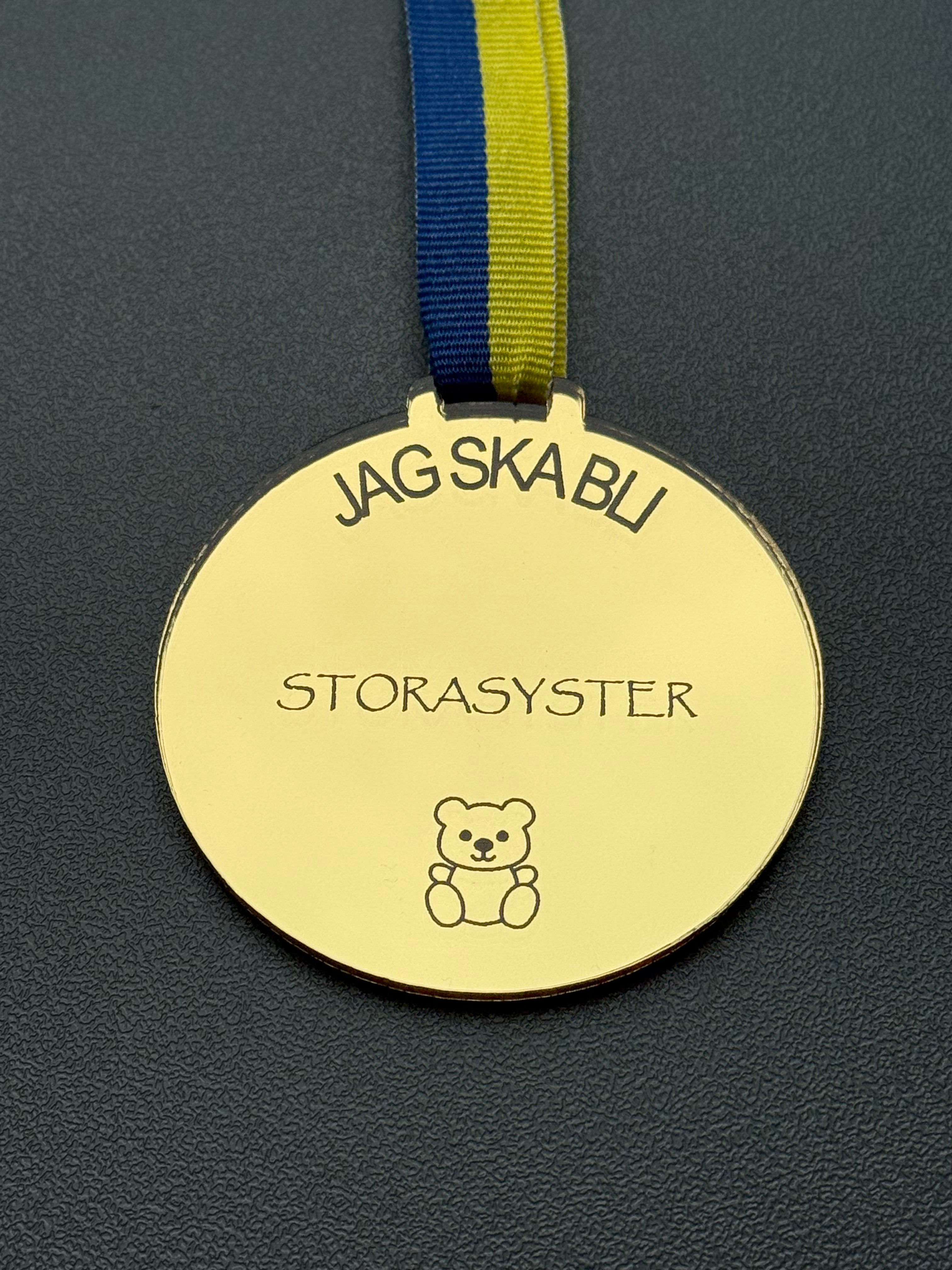 Present till storasyster, en rund guldmedalj i spegelplast