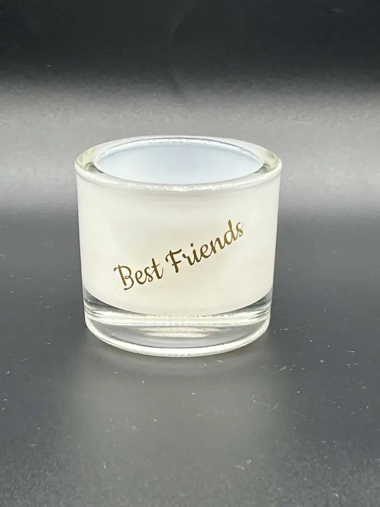 Ljusstaken Lykta Best Friends från Expresspresenter.se har klart glas, vita frostade sidor och "Best Friends" i guldkursiv - perfekt för att visa värmeljus mot en mörk bakgrund.