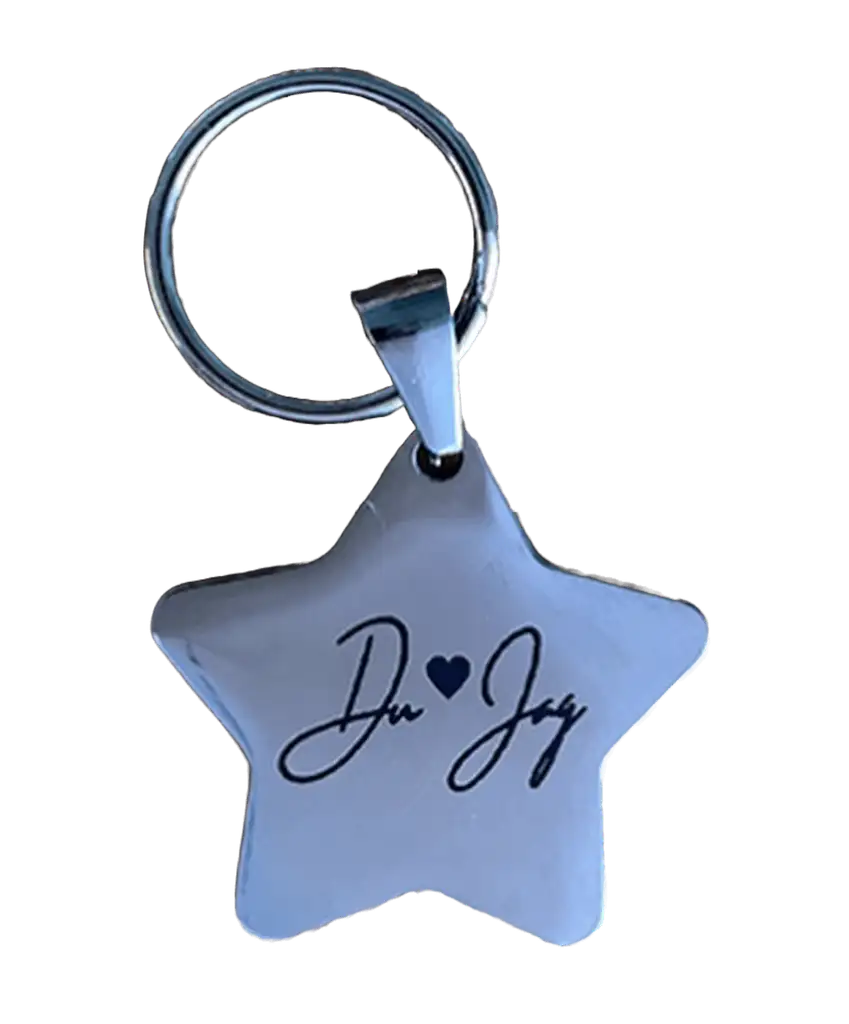 Nyckelrings stjärna du & jag från Expresspresenter.se är en nyckelring i silver med "Du & Jag" och ett litet hjärta ingraverat i svart skrift på den stjärnformade ytan i rostfritt stål.