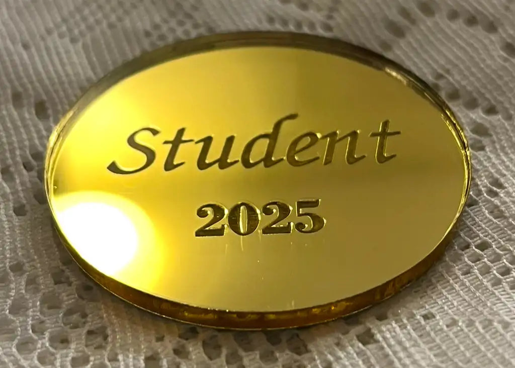 En guldglänsande Placeringskort runda från Express-presenter, graverad med "Student 2025", vilar på en vit, strukturerad tygbakgrund.