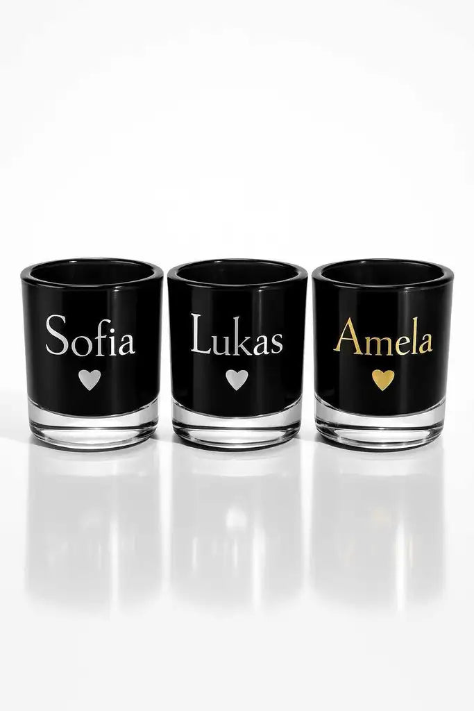 Tre svarta glasljuslyktor från Express-presenters serie "Ljuslykta | Namn & Hjärta", med namnen Sofia, Lukas (vit) och Amela (guld) tryckta ovanför en hjärtsymbol.