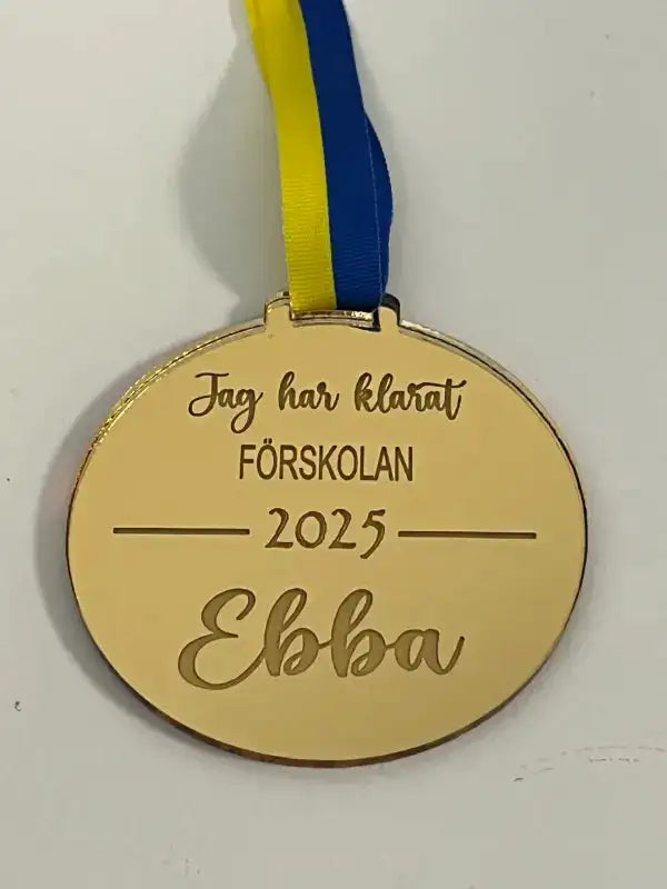En guldmedalj | Jag har klarat FÖRSKOLAN i skrivstil från Express-presenter, med blått och gult Sverigeband, graverad på svenska: "Jag har klarat FÖRSKOLAN 2025 [eget namn]", personifierad med ditt eget namn.