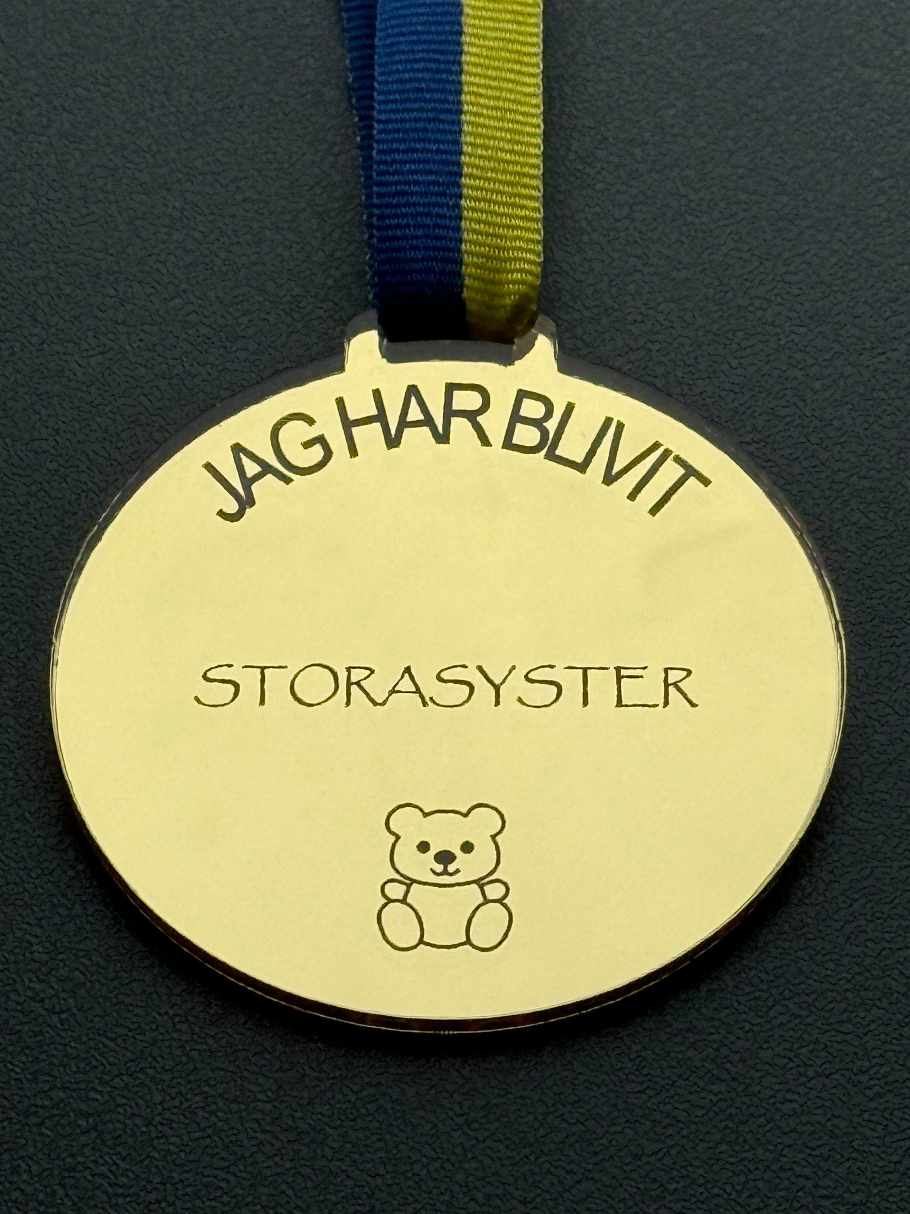stolthet och glädje gåva
spegelplast medalj barn
present till storasyster
personlig medalj med text
minnesmedalj barn
medalj tillverkad i Sverige
medalj jag har blivit storasyster
lasergraverad medalj guld
guldfärgad medalj 3mm
barnpresent unikt minne
