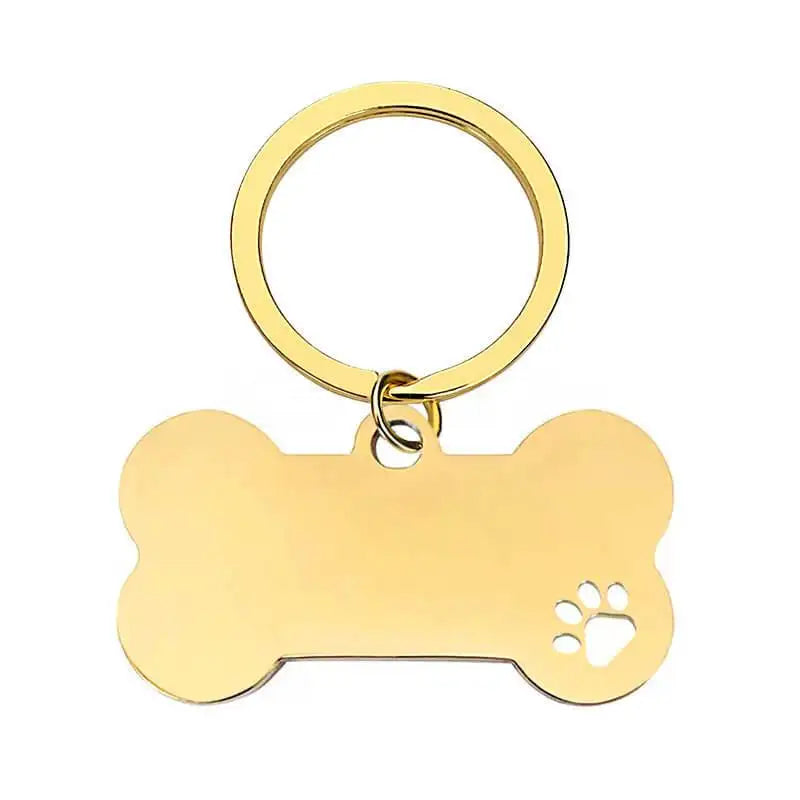 Nyckelring | Hundben by Express-presenter är en benformad nyckelring i guld med ett tassavtryck utskuret i nedre högra hörnet.