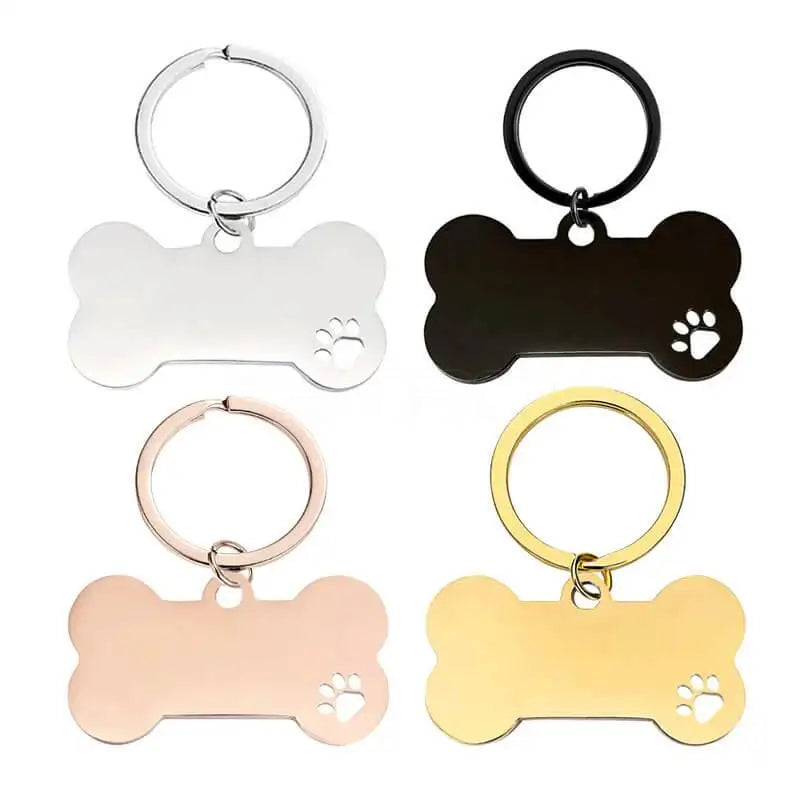 Fyra metallnyckelringar i form av hundben från Express-presenter, i silver, svart, roséguld och guld med tassavtryck. Nyckelring | Hundben - perfekt som personlig eller lasergraverad nyckelring.