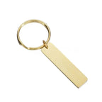 Nyckelring | Take Care by Express-presenter är en guldfärgad nyckelring med en rektangulär, platt tagg (12 x 50 mm) tillverkad av rostfritt stålsmycke, mot en vit bakgrund.