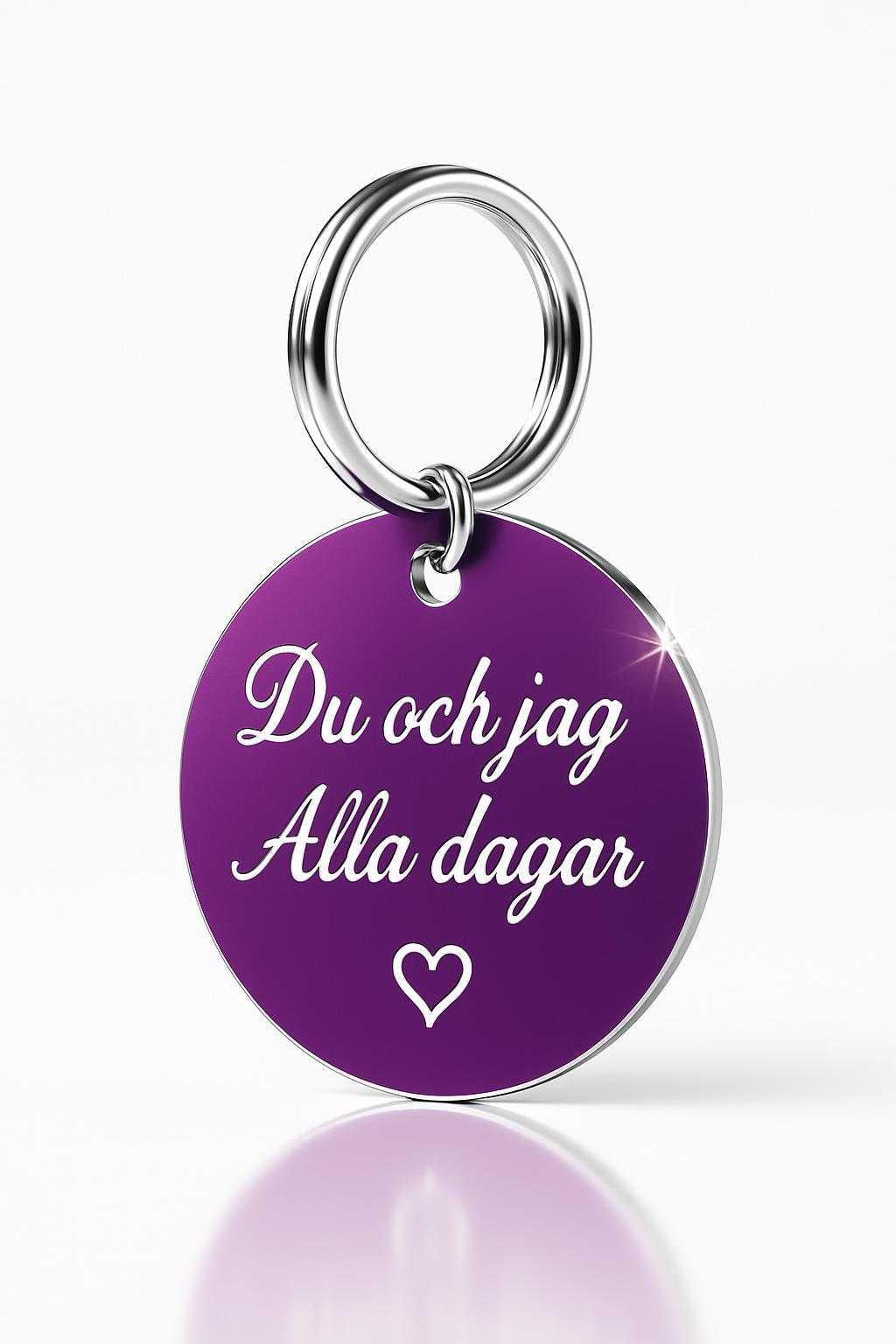 lila rund nyckelring med vit text