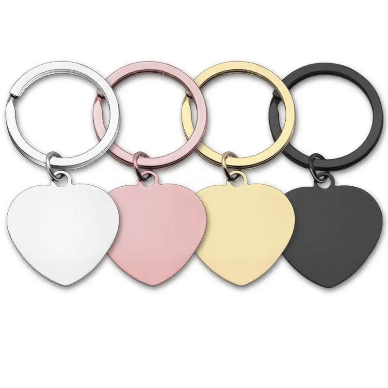 Fyra hjärtformade nyckelringar i rostfritt stål från Express-presenter syns i silver, rosa, guld och svart. Varje "Nyckelring | Märk din ryggsäck" har en matchande ring-perfekt för ryggsäcken eller nycklarna.