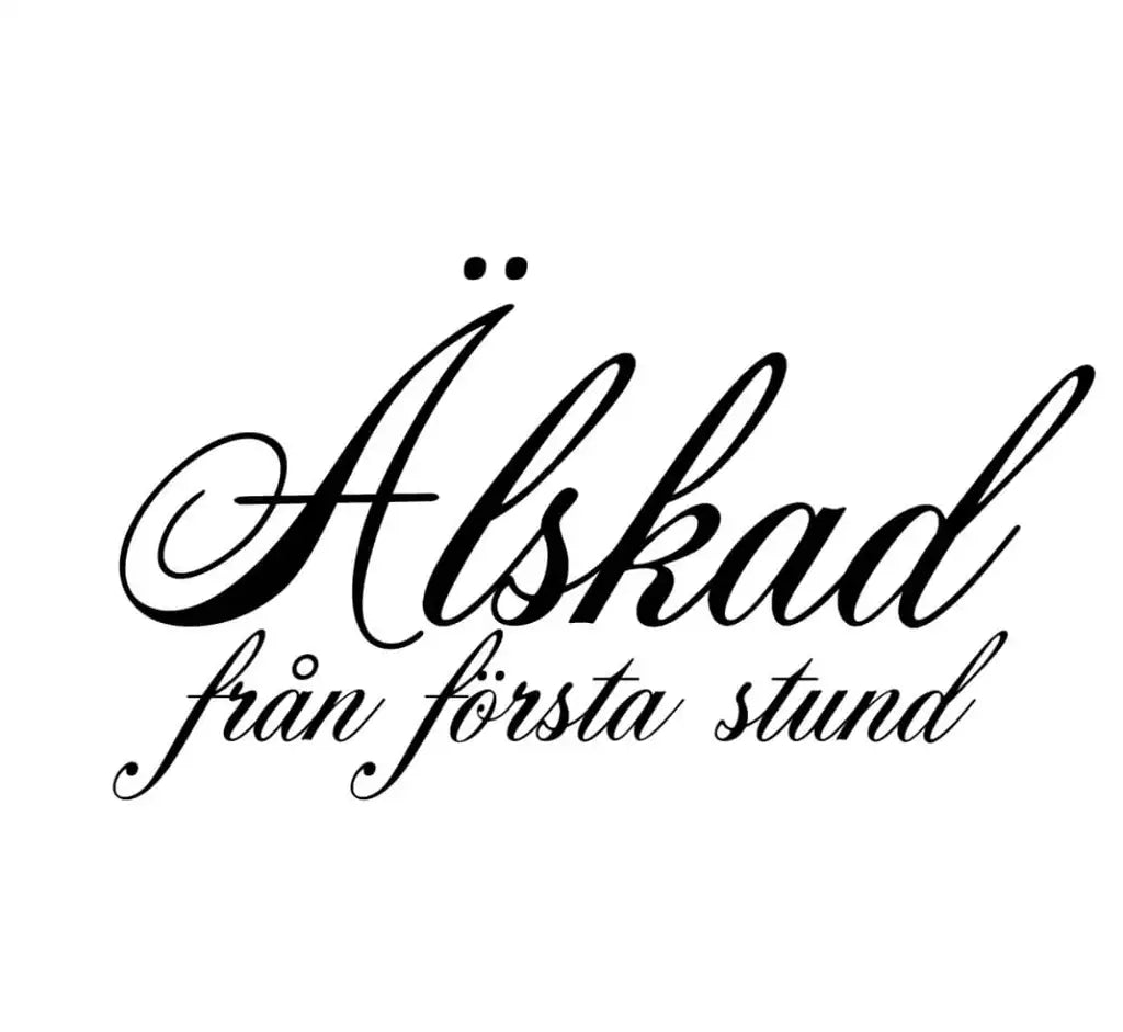 Bilden visar Expresspresenter.se:s Textdekal | Älskad från första stund, med den svenska frasen i elegant svart kursiv på en vit 700x250mm självhäftande vinyldekal.