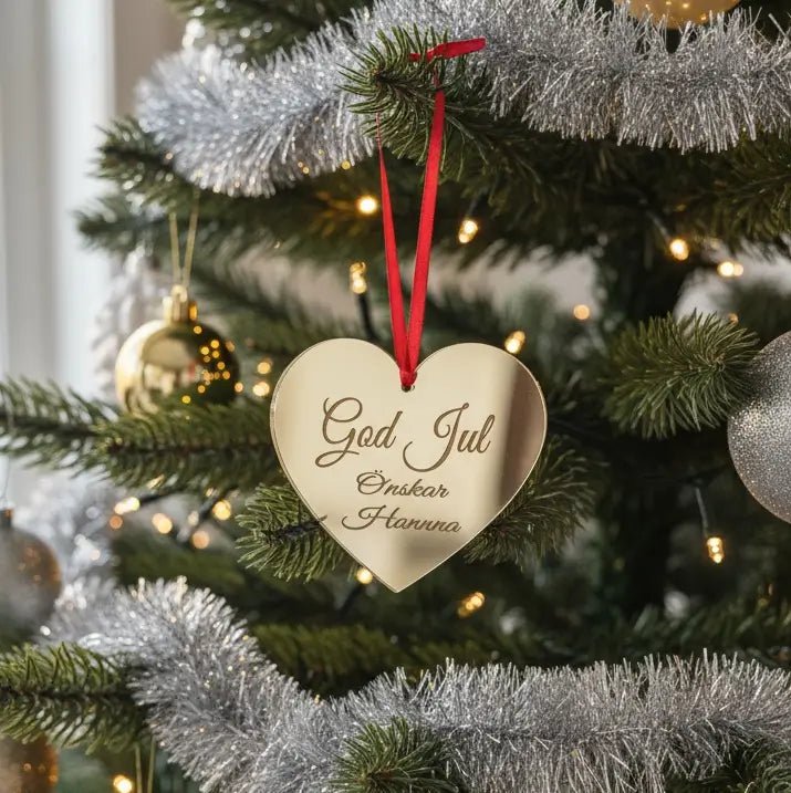 Julhänge i form av ett rött hjärta med texten “God Jul önskar” och rött satinband – perfekt julgransdekoration